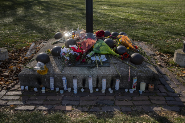 2021年11月23日，威斯康星州沃科夏（Waukesha）市中心的主街上，人们为22日发生的驾车杀人惨案摆放鲜花和点蜡烛，以纪念受害者们。（图片来源：Jim Vondruska/Getty Images）