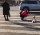 女子无视车辆将婴儿放斑马线爬行(视频)