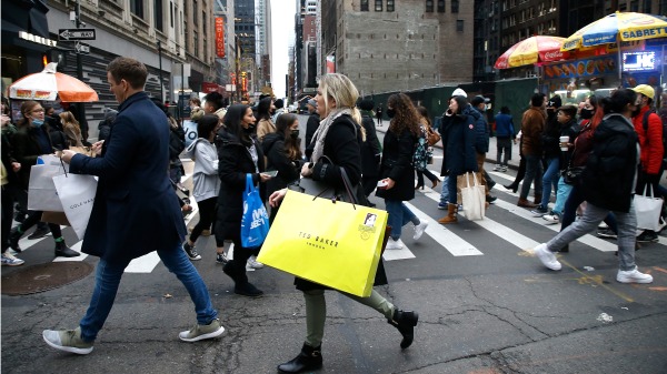 2021年11月26日黑色星期五，美國民眾走在紐約街道上提著剛剛搶購的戰利品。（圖片來源：John Lamparski/Getty Images)