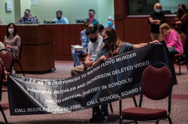 圖為2021 年 10 月 12 日，在美國弗吉尼亞州阿什本舉行的勞登郡公立學校董事會會議上，一名家長舉著反對批判種族理論 (CRT) 的橫幅。（圖片來源：ANDREW CABALLERO-REYNOLDS / Colaborador/Getty Images）