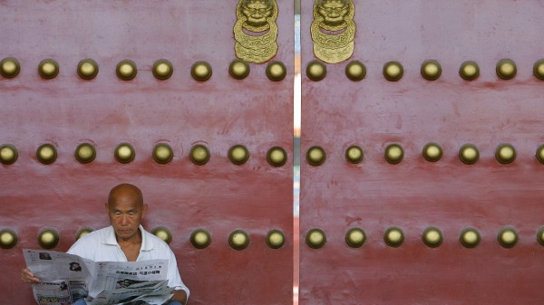紫禁城外一位老人在读报纸。（图片来源：Getty Images）