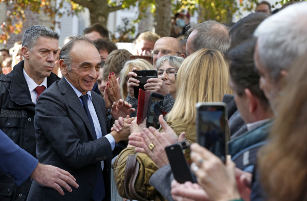 2021年10月23日，法国作家埃里克·泽穆尔抵达新书发布会时与他的支持者握手。