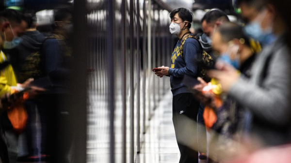 疫情导致不少香港家庭收入下跌。图为月台上，等候乘搭地铁的香港市民。（图片来源：Getty Images）