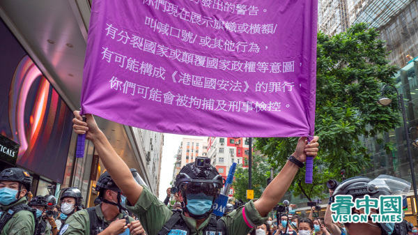 2020年《港區國安法》生效，港警高舉舉紫旗警告香港市民噤聲。（圖片來源：龐大衛/看中國）