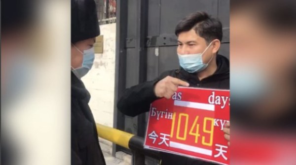  巴依布拉提在中国驻阿拉木图领事馆门前和平示威期间，跟当地员警对谈画面。