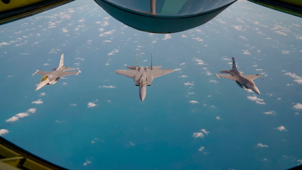 图为2018年1月17日，新加坡空军的一架F-15SG战斗机（中）在两架F-16C战斗机伴随下飞越南海。（图片来源：NICHOLAS YEO/AFP via Getty Images）