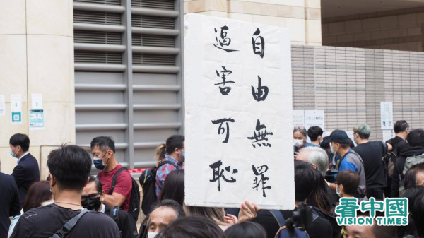 圖為3月1日，47名民主派人士提堂，有港人在法院外手舉「自由無罪 迫害可恥」的標語。