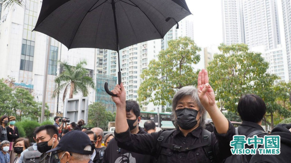 有市民舉起黑色雨傘，做出支持緬甸抗爭者手勢。（圖片來源：李天正/看中國）