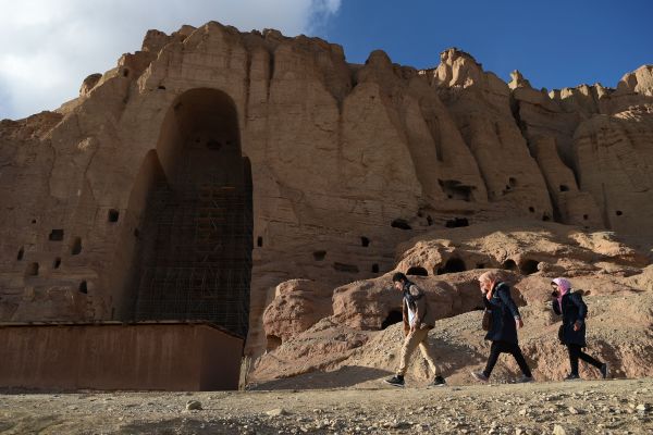 2021年3月3日，几名阿富汗人在巴米扬省被毁的巨型佛像的遗址前走过。