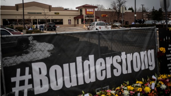 2021年3月22日，美国科罗拉多州超市爆发致命枪击案的第二天，人们在超市外的围栏旁放置鲜花（图片来源：