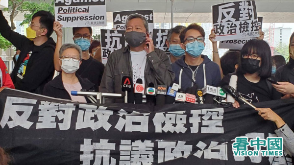 香港政府起诉参与8.18维园“流水式集会”的9名民主派人士，一众人士和支持者在进入法院前举横幅抗议政府正在打压。（图片来源：宇星/看中国）