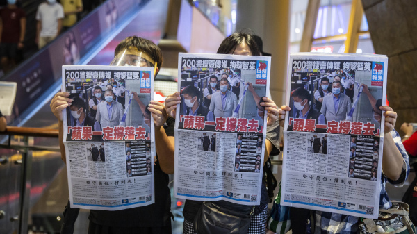 壹传媒老板黎智英遭港府以国安法拘捕后，港人买《苹果日报》以示声援。（图片来源：ISAAC LAWRENCE / Getty Images）