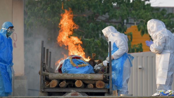 2021年4月26日，印度COVID19死者家屬在遺體露天火化場。（圖片來源：MANJUNATH KIRAN/AFP via Getty Images）(