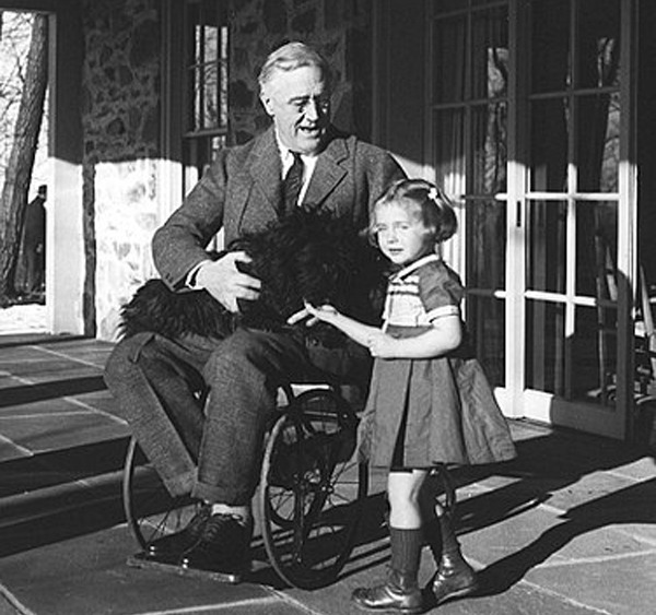 罗斯福坐轮椅的少量照片之一，怀抱中的为其爱犬法拉。