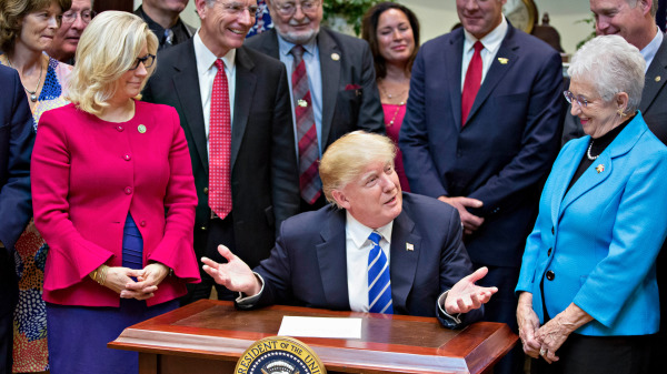 时任美国总统川普在白宫罗斯福厅举行的法案签署仪式上与共和党北卡罗来纳州代表弗吉尼亚．福克斯（Virginia Foxx，右）和怀俄明州代表利兹．切尼（Liz Cheney，左）讲话。