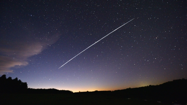 这是一张经过长时间曝光的图片，图中显示了SpaceX公司发射的一组星链（Starlink）卫星从南美国家乌拉圭上空掠过的轨迹，视角为美国佛罗里达州的某地。（图片来源：Mariana Suarez/AFP via Getty Images）