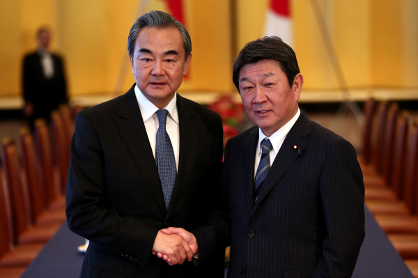2019年11月25日，中国外长王毅与日本外相茂木敏充在东京举行的新闻发布会握手。