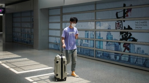 2020年5月2日，一名男子拖着行李箱走在上海机场　