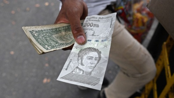  2021年4月14日，一名男子在委内瑞拉加拉加斯的街道上展示新的200万面值的玻利瓦尔纸币。（FEDERICO PARRA/AFP via Getty Images ）