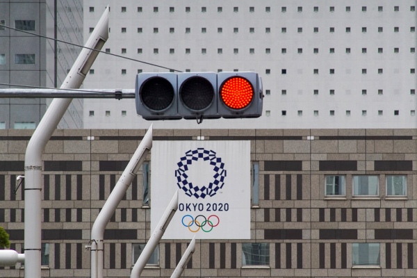 2021年5月31日，在東京都政府大樓附近的一條街道上，一條紅色交通燈亮起，上面掛著東京2020年東京奧運會的橫幅。