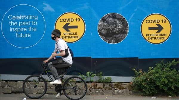 6月9日，路人经过英格兰博尔顿（Bolton）Covid-19测试中心的广告。