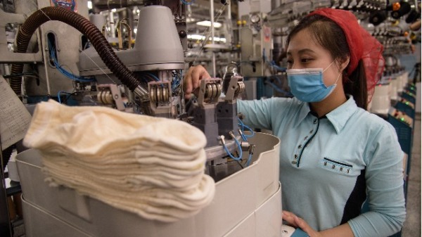 2021年5月24日，一名女工在朝鮮平壤襪廠生產線上工作。