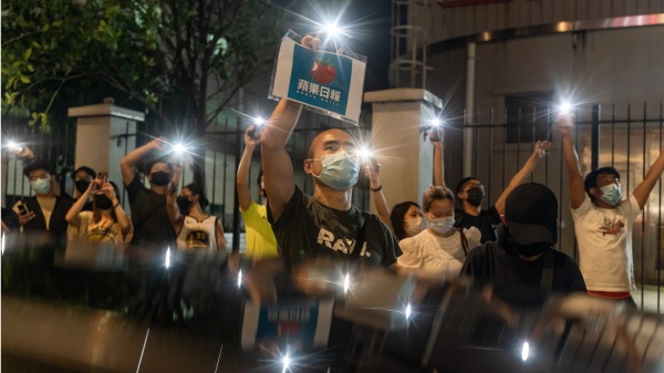 圖為6月24日《蘋果日報》被迫停刊，大批市民聚集在蘋果日報大樓外，向大樓內揮舞手機燈以示支持。（圖片來源：Getty Images）