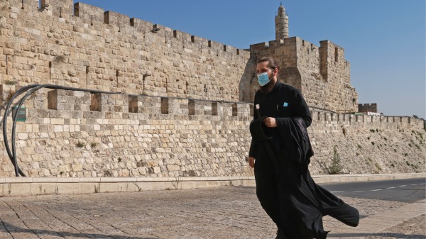2020年9月12日，在COVID-19大流行期間一名戴口罩的牧師走在耶路撒冷舊城街道上。