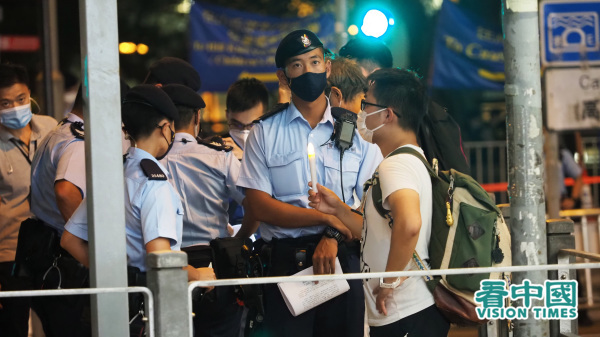 手持蜡烛的市民遭警方包围截查。（图片来源：李天正/看中国）