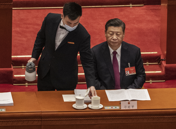 2021 年的全国人民代表大会开幕式上，男服务员为习近平主席倒茶。