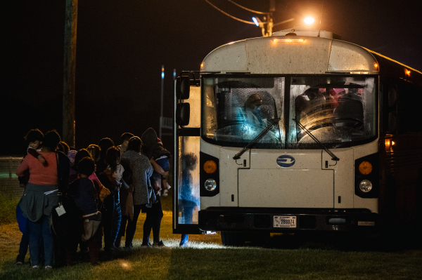 图为2021年6月21日夜间，美国边境巡逻队在德州与墨西哥接壤的边境地带拦截住不少非法越境的非法移民，并把他们送上一辆车去边境移民设施处等待进一步处理。