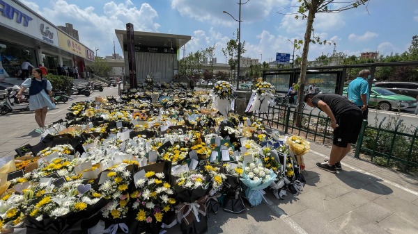 7月27日，河南鄭州市民在地鐵5號線站臺前給洪災死難者獻花，鞠躬默哀，寄託哀思。