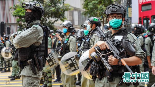 大年初三香港发生警员开枪案，事后有前警司分析，事件反映香港警队存在人手不足、训练不足等深层次问题。图为反送中期间持枪的防暴警员。（摄影：Adrian/看中国）