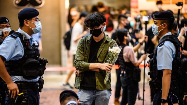 反送中後，香港年輕人成為政府整治的對象。圖為2021年7，警察在街頭截查一位男青年的随身物品。（圖片來源：Getty Images）