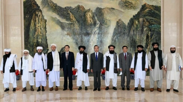 7月28日塔利班联创人巴拉达率领的代表团和中共外交部长王毅，在天津会晤合影。（
