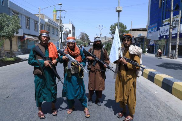 2021年8月19日，在塔利班军事接管阿富汗的过程中，几名塔利班成员在阿舒拉游行现场附近的道路上。