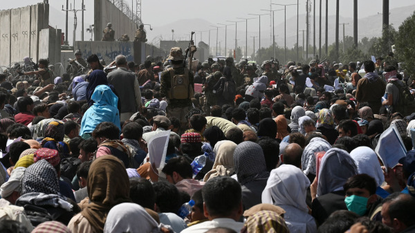 成千上万的阿富汗人密密麻麻拥挤在喀布尔机场军事区域附近的路边上，希望在塔利班军事接管阿富汗后逃离该国