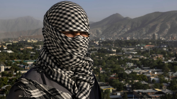 一名与美国军方合作了13年的阿富汗人在阿富汗喀布尔接受媒体拍照，但他要求蒙面