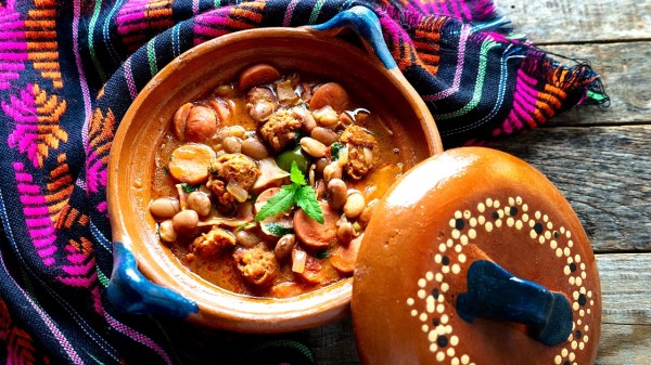 墨西哥豆被稱為“charros”，木製背景上有香腸和培根
