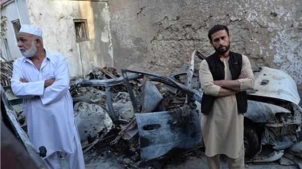 2021年9月18日，被美軍無人機誤殺的阿富汗平民艾哈邁迪（Ezmarai Ahmadi）的弟弟站在8月29日被無人機投下的地獄火箭HOSHANG HASHIMI/AFP via Getty Images)彈擊中的車旁。